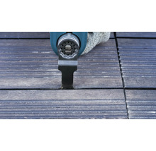 Oscillerend elektrisch gereedschap snijdt een voeg in terrasplanken