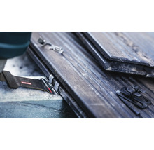 Gedetailleerde opname van een zaagblad dat dakpannen met bevestigingsclips zaagt