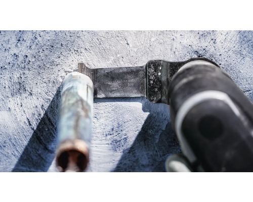 Multifunctioneel gereedschap met metalen zaagblad snijdt een metalen buis