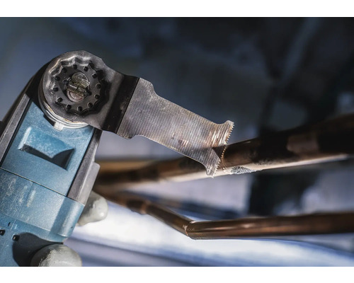 Oscillerend multifunctioneel gereedschap snijdt een koperen pijp.