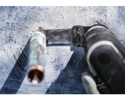 Oscillerend elektrisch gereedschap met metalen zaagblad dat een metalen buis doorsnijdt.
