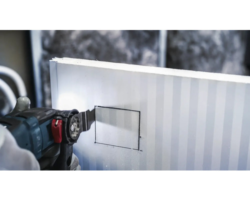 Een oscillerende zaag snijdt in een isolatieplaat.