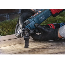 Een persoon gebruikt een Bosch multitool om hout te snijden