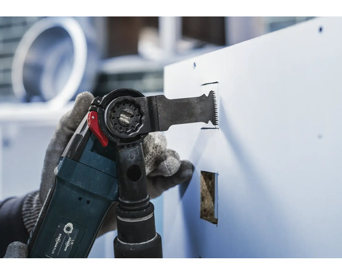 Multifunctioneel gereedschap in gebruik bij het zagen in een plaat