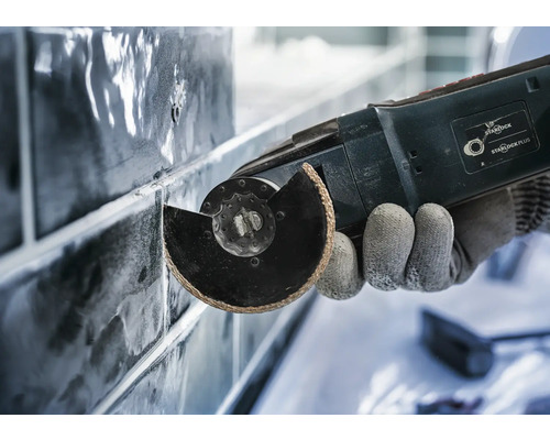 Close-up van een multitool die tegels snijdt