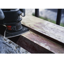 Driehoekschuurmachine schuurt een stuk hout