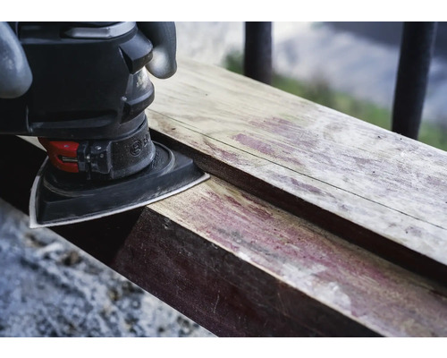 Driehoekschuurmachine schuurt een stuk hout