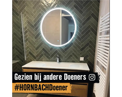 Badkamer met wastafel, spiegel met verlichting en handdoekradiator.