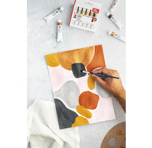 Een persoon schildert een abstract kunstwerk op papier met acrylverf, omringd door tubes verf en een verfdoos.