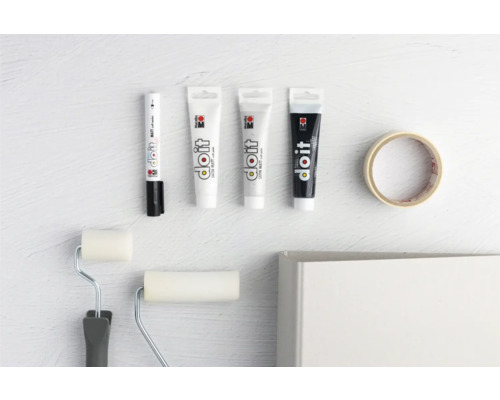 Verfstiften, verftubes, verfrollers en afplakband op een lichte achtergrond