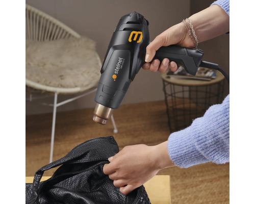 Heteluchtpistool in gebruik op een leren tas