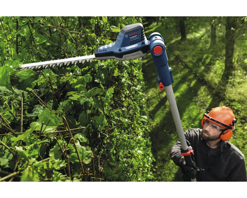 Persoon snoeit heg met een Bosch accu telescoop heggenschaar