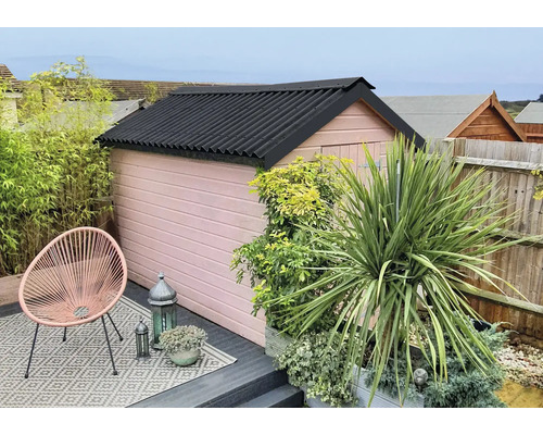 Tuinaanzicht met schuur, planten en zitgelegenheid