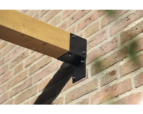 Houten balk bevestigd met een zwarte beugel aan een bakstenen muur