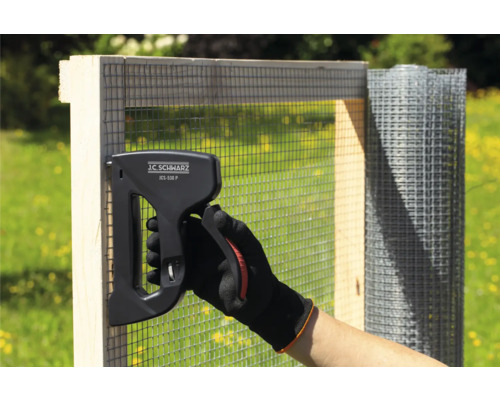 Persoon bevestigt draadgaas met een J.C. Schwarz JCS-530 P nietapparaat aan een houten frame