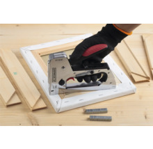 Hand met tacker op spieraam