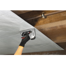 Iemand bevestigt folie met een handtacker aan een houten plafond.