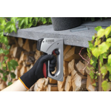 Een hand gebruikt een J.C. SCHWARZ tacker om nietjes te bevestigen.