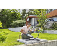 Man gebruikt een Gardena regentonpomp in de tuin voor tuinirrigatie.
