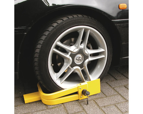 Gele wielklem op een autoband voor beveiliging