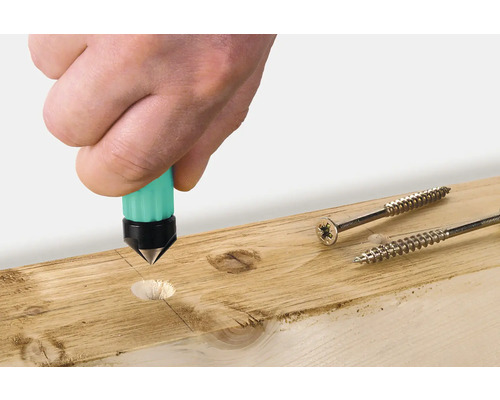 Een hand gebruikt een centerpons op een houten plank naast twee schroeven.