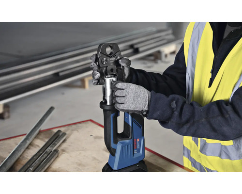 Een werknemer bedient een Bosch accu-perstang voor het persen van buizen.