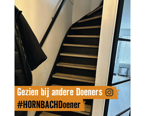 Trap met houten treden en zwarte leuning binnenshuis