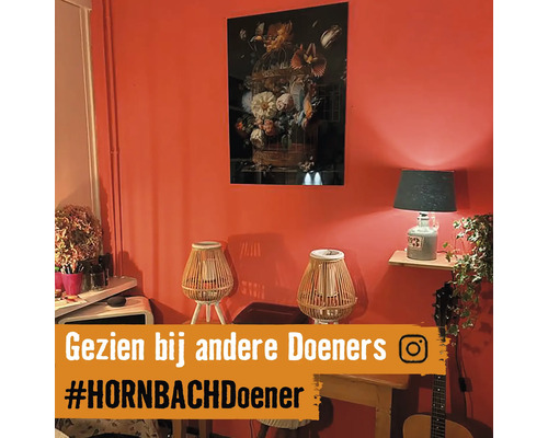 Decoratieve woonkamer met schilderij, tafellampen en kamerplanten.