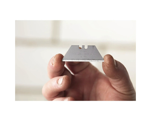 Een trapeziumvormig mes wordt door een hand vastgehouden.