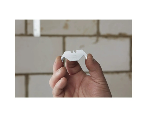 Persoon houdt een trapeziumvormig mes vast voor een stanleymes