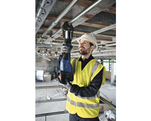 Ambachtsman die een pijptang gebruikt om leidingen te krimpen op een bouwplaats.