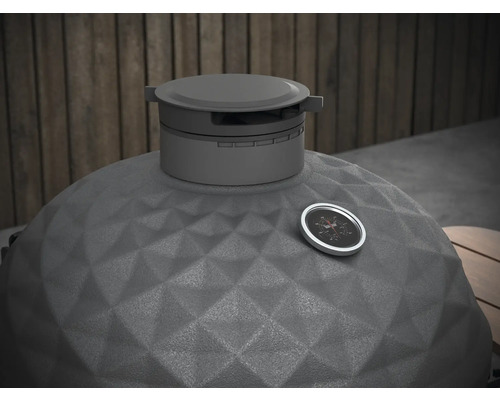 Detailopname van een kamado barbecue met temperatuurmeter en gestructureerd keramisch oppervlak