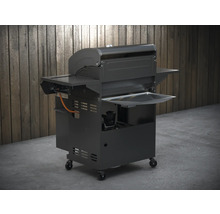 Gasbarbecue met opbergvakken en wielen tegen houten wand