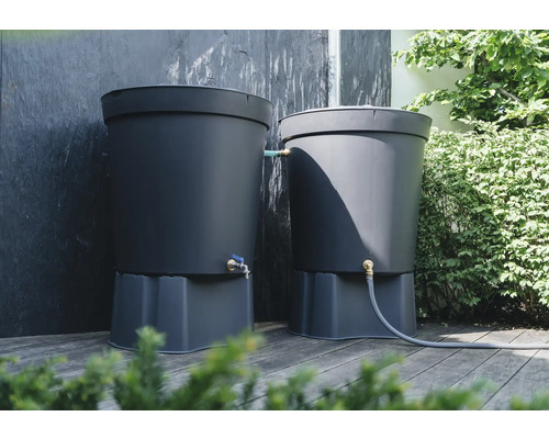 Twee donkergrijze regentonnen met kraan op een houten terras