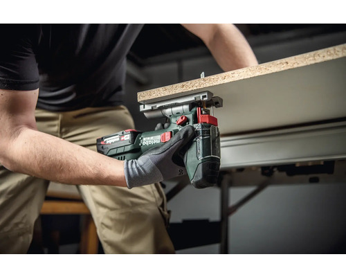 Ambachtsman gebruikt een Metabo accu-metaalschaar om een werkstuk te snijden