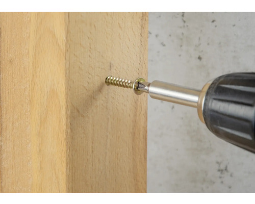 Een schroef wordt met een accuschroevendraaier in een houten plank geschroefd.