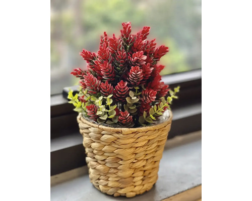 Kunstplant met rode bloemen in een gevlochten pot