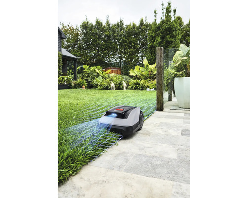 Robotmaaier op gazon en stenen platen