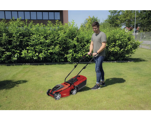 Man maait gazon met een gazonmaaier in de tuin.