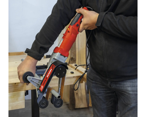 Een man bedient een langbandschuurmachine van Holzmann.