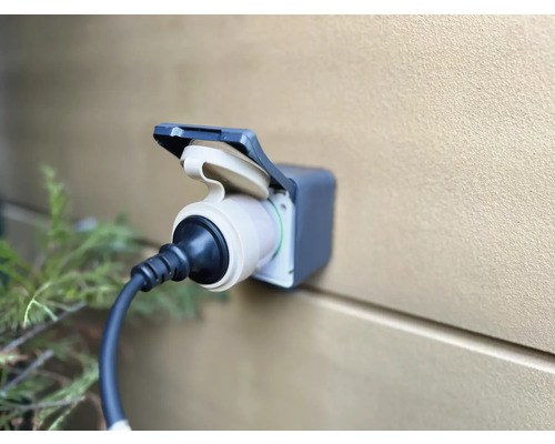 Elektrische autolaadstation met aangesloten stekker aan een muur