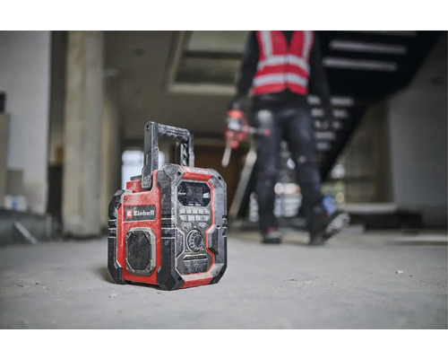 Een bouwradio van het merk Einhell staat op de grond van een casco.