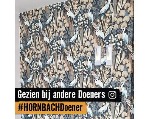 Wand met behang met reigerpatroon en twee wandlampen