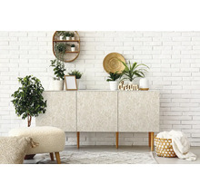 Lichte kamer met dressoir, planten en decoratie tegen een witte bakstenen muur