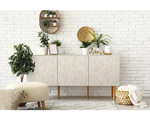 Lichte kamer met dressoir, planten en decoratie tegen een witte bakstenen muur