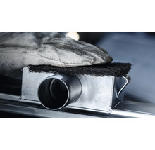 Een hand met een werkhandschoen houdt een schuurspons op een metalen buis.