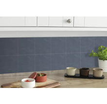 Keukenscène met blauwe wandtegels, aanrecht en keukengerei.
