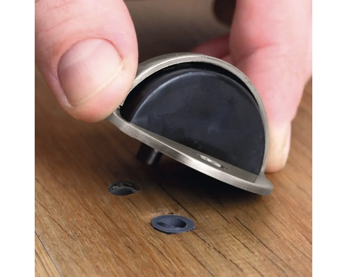 Montage van een deurstoppper op een houten vloer.