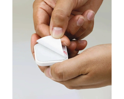 Handen verwijderen de beschermfolie van een zelfklevende pad