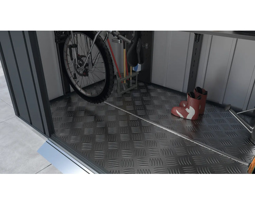 Interieur van een tuinhuis met fiets, tuingereedschap en laarzen op een traanplaatvloer